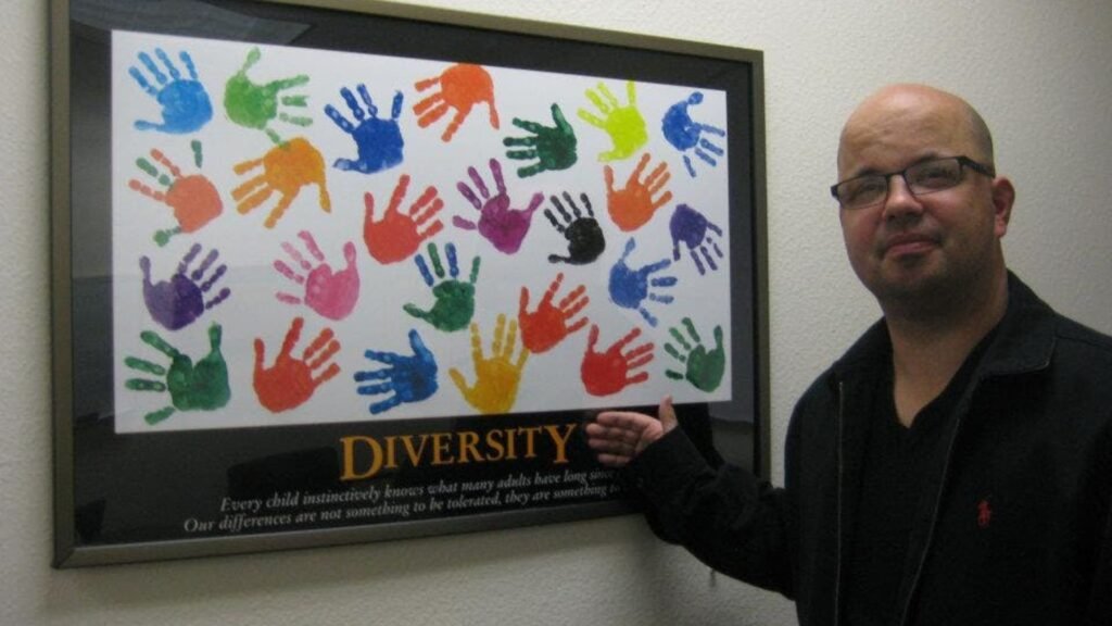 Mark Chartier with a diversity print featuring a group of multi-colored hands